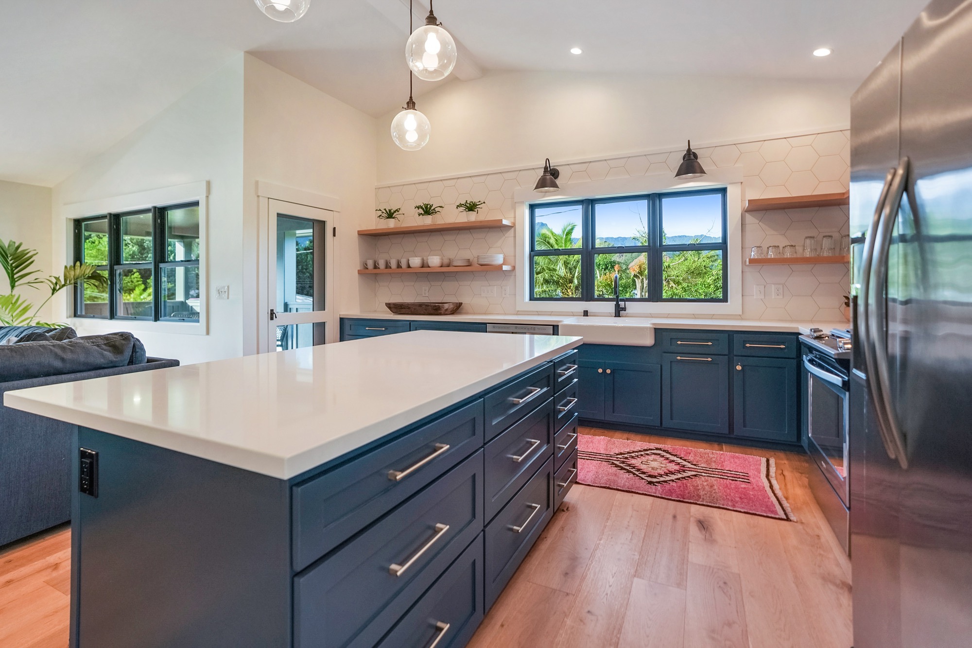 a kitchen with a sink a counter top space stainless steel appliances a large window and cabinets