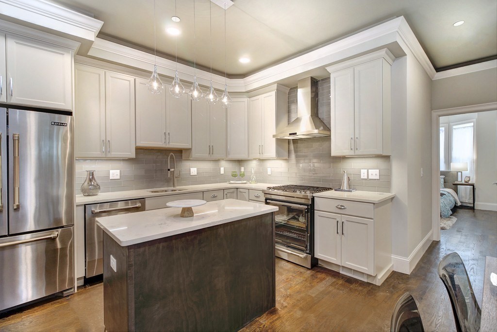 a kitchen with stainless steel appliances granite countertop a sink stove and refrigerator