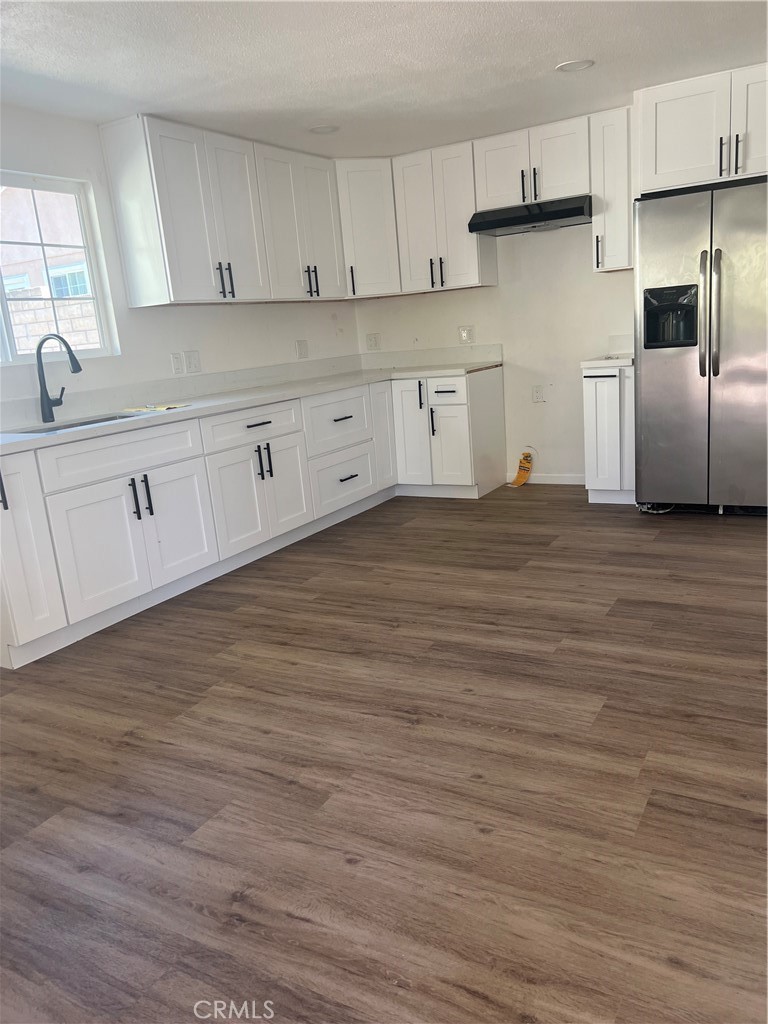 a kitchen with granite countertop white cabinets and stainless steel appliances