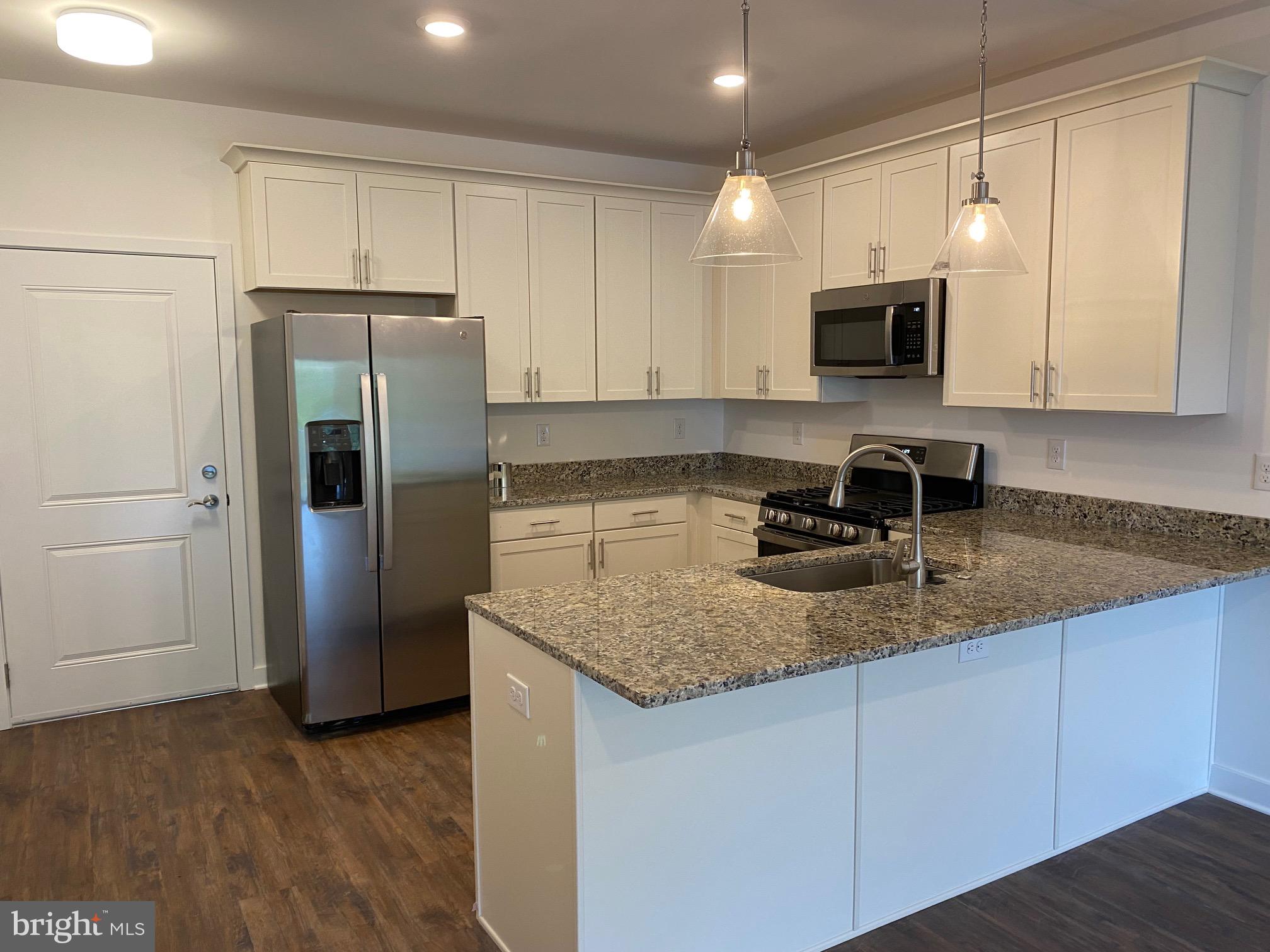 a kitchen with stainless steel appliances granite countertop a refrigerator sink and microwave