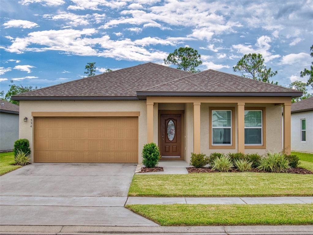 a front view of a house with a yard and garage