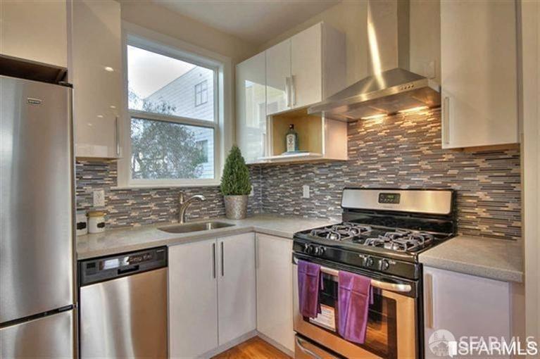 a kitchen with stainless steel appliances a stove a sink and a refrigerator