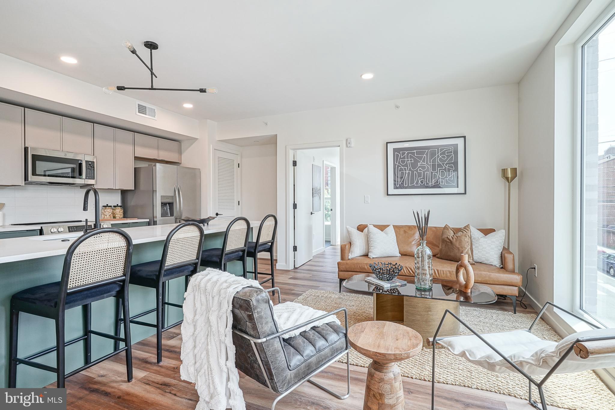 a living room with lots of furniture and a view of kitchen