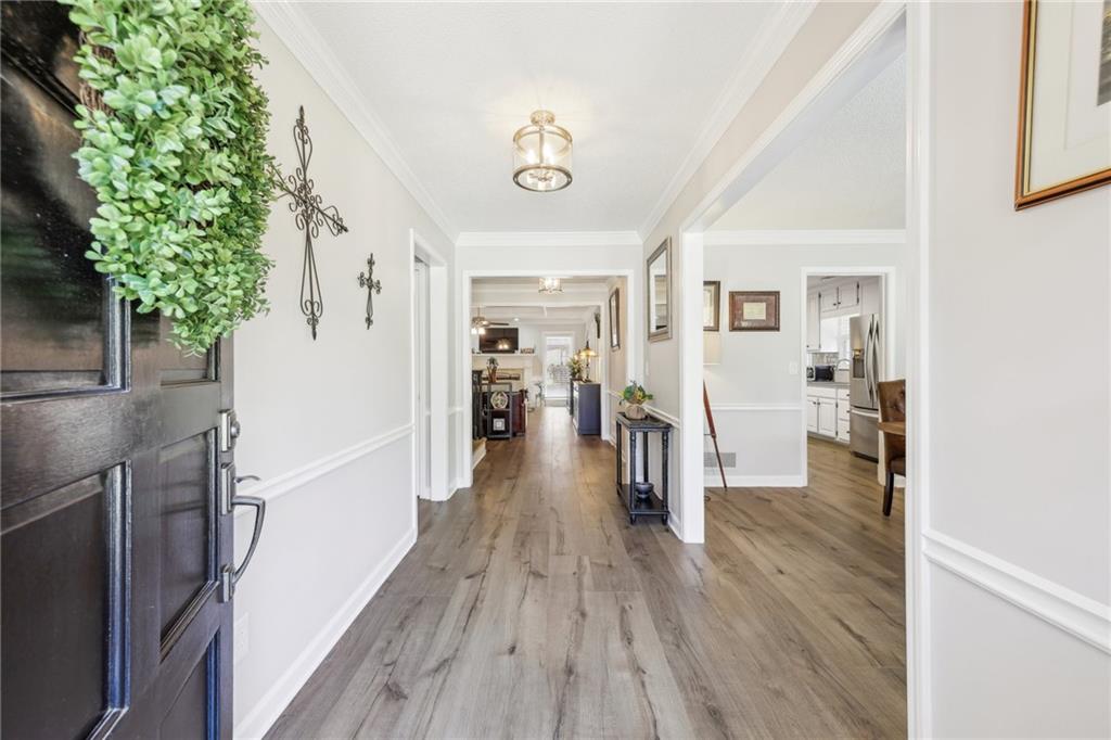 a hallway with wooden floor electronic appliances and furniture