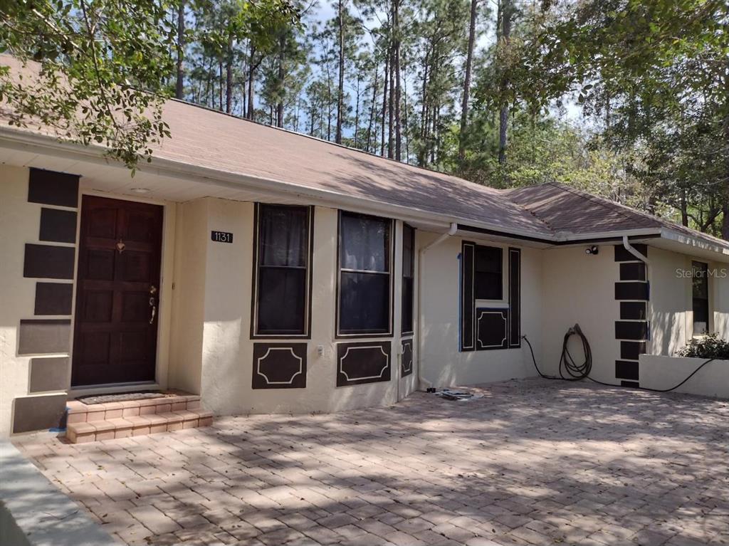 a view of a house with a patio and a yard