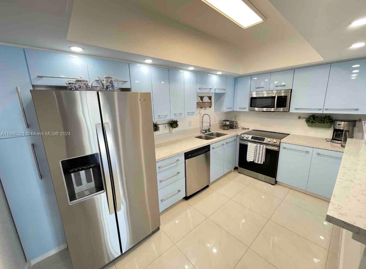 a kitchen with stainless steel appliances granite countertop a stove a sink dishwasher a refrigerator and a refrigerator