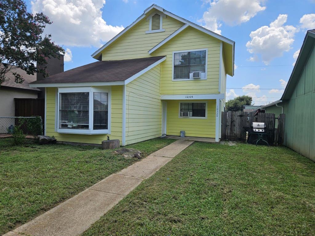 a front view of a house with a garden and yard