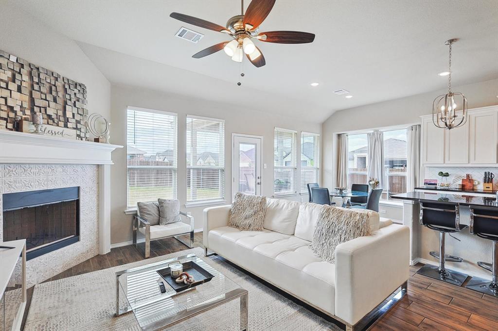 a living room with furniture fireplace and a large window