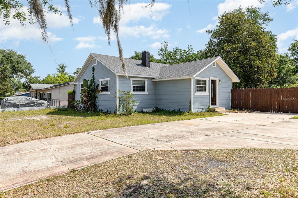 a view of a house with a backyard and a tree