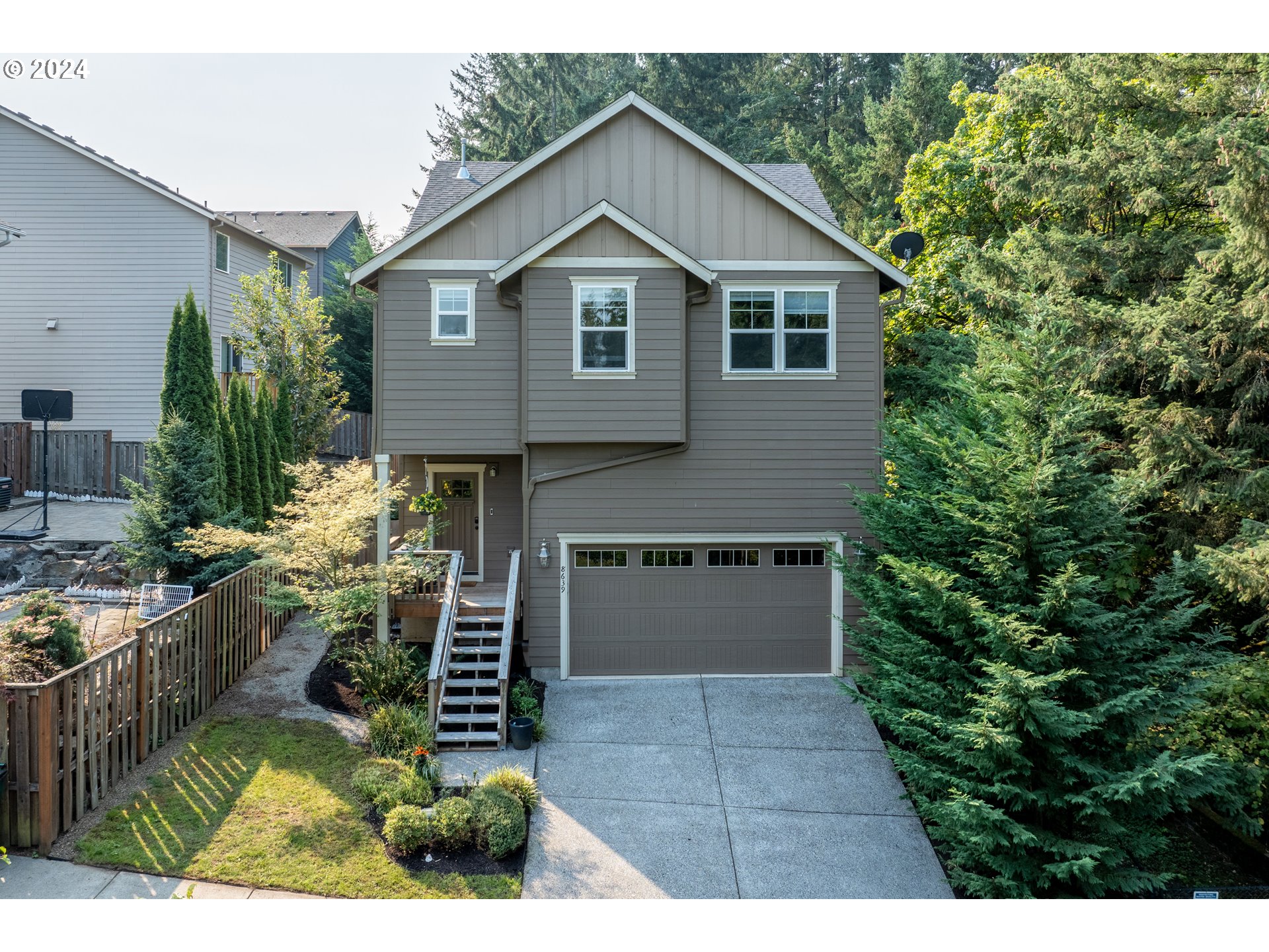 a front view of a house with a yard and potted plants