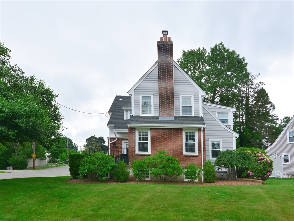 a front view of a house with a yard and trees