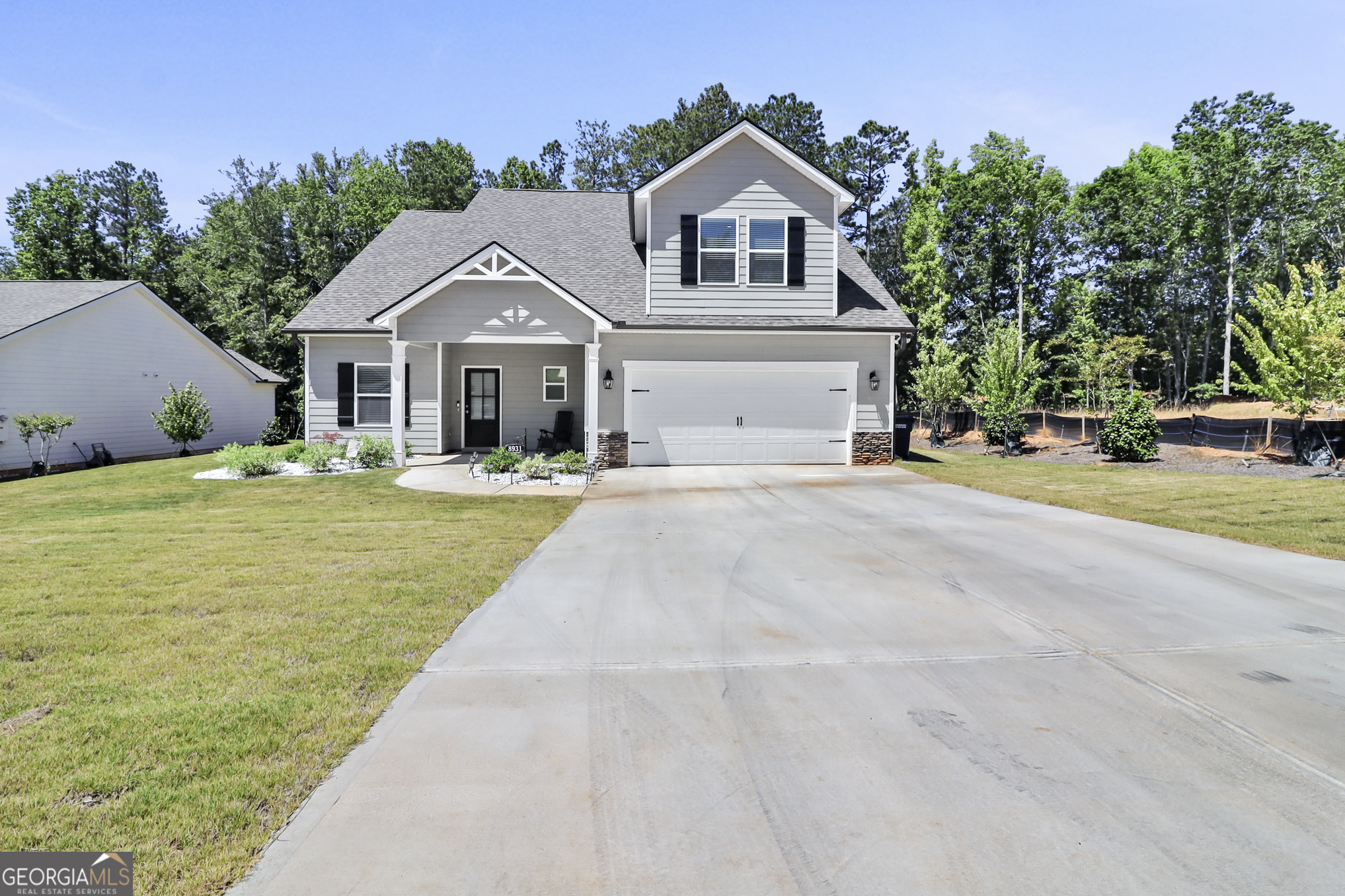 a front view of a house with yard and green space