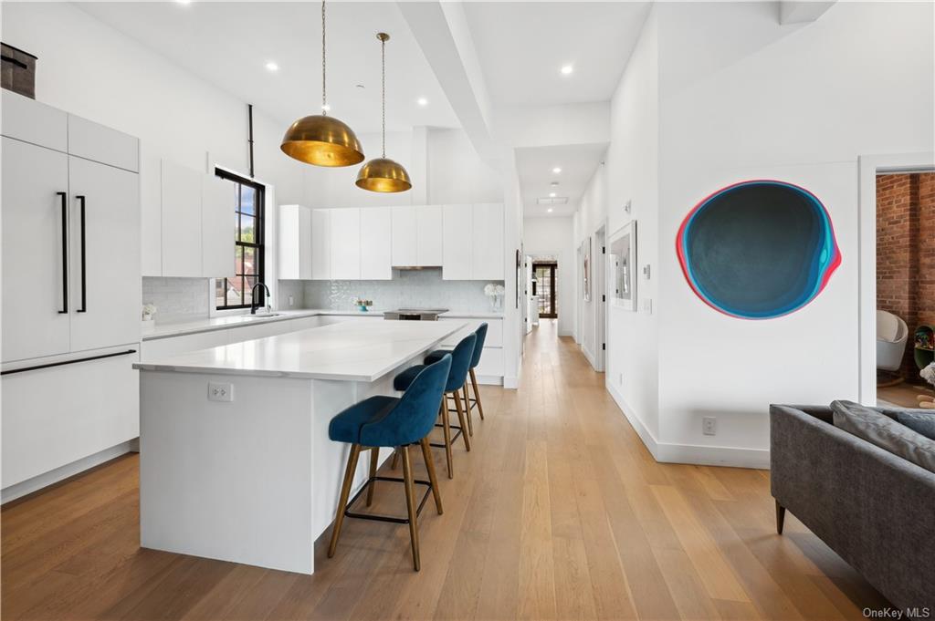 a kitchen with stainless steel appliances granite countertop a sink a stove and a wooden floors