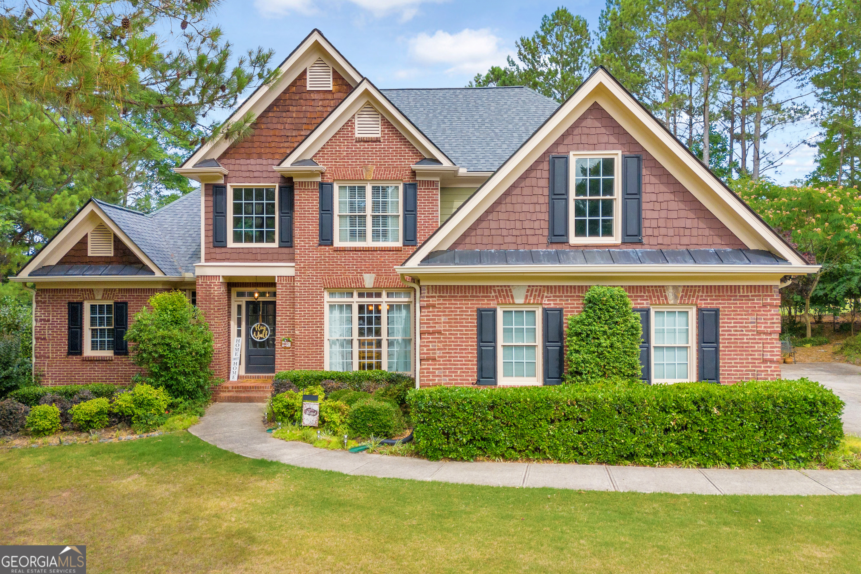 a front view of a house with a yard and potted plants