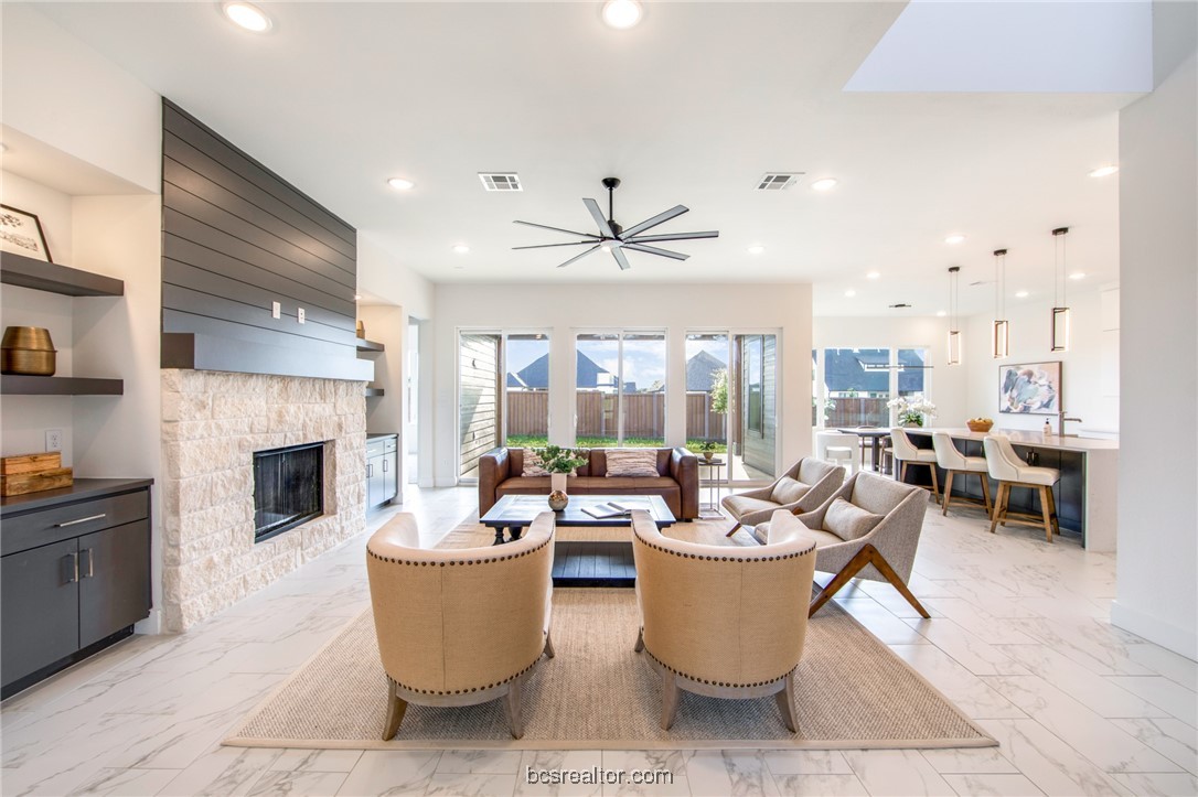 a living room with furniture a fireplace and a chandelier