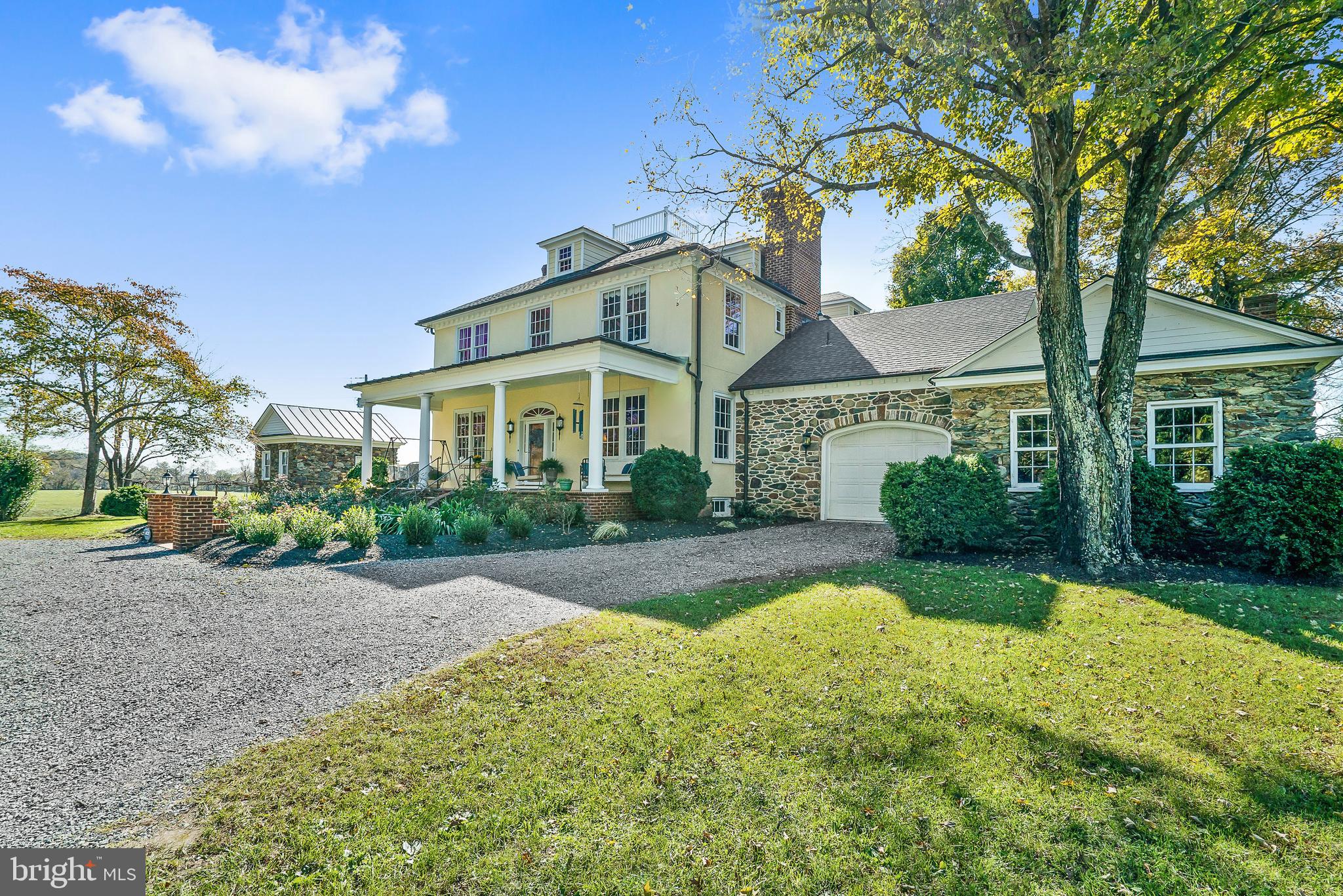 a front view of a house with a garden and trees