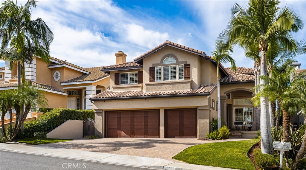 a front view of a house with a yard and palm trees