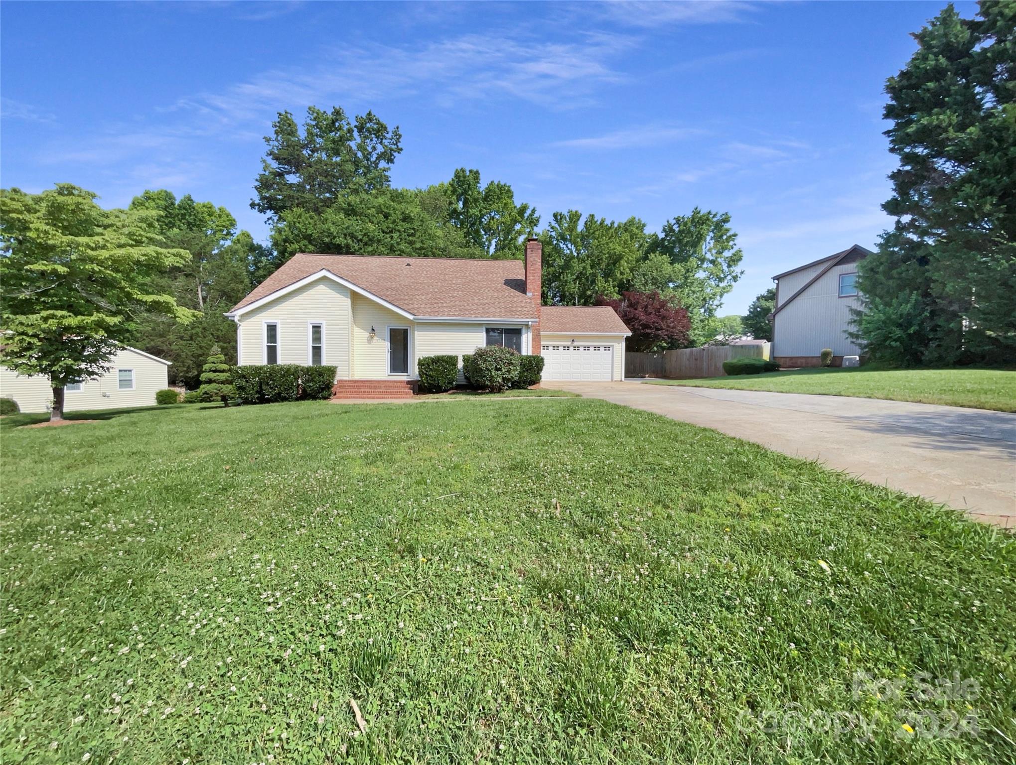 a front view of a house with a yard and trees