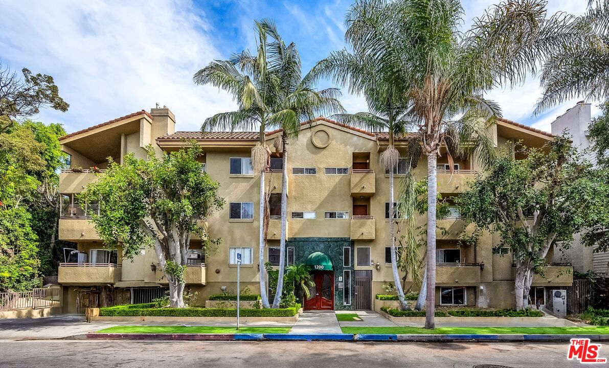 a front view of a residential apartment building with a yard