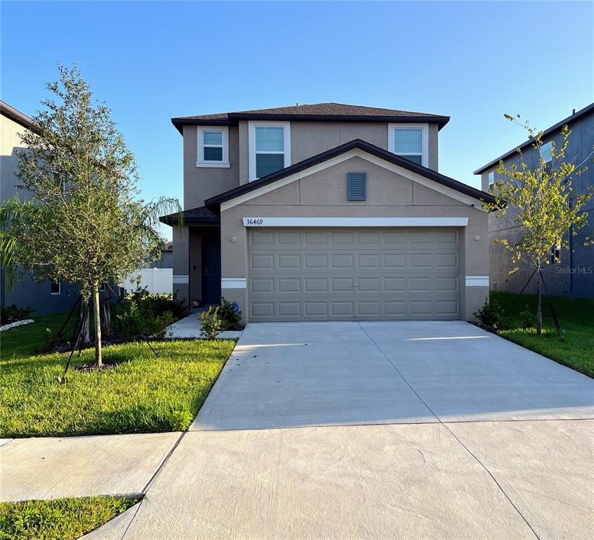 a front view of a house with a yard and garage