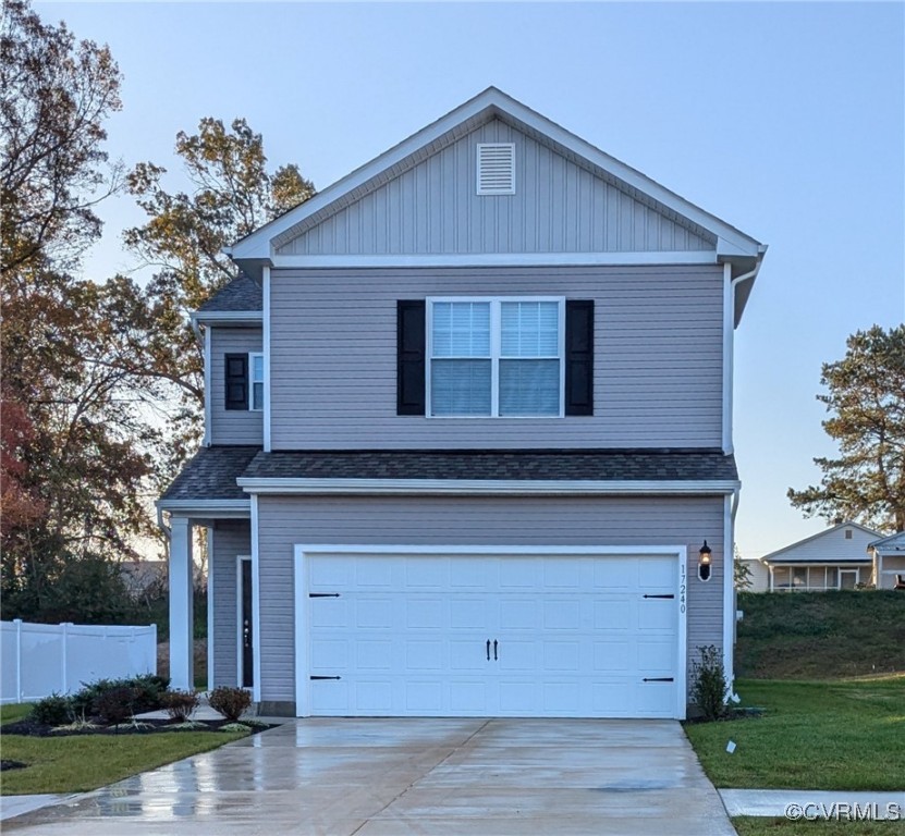 Front facade featuring a front yard and a garage