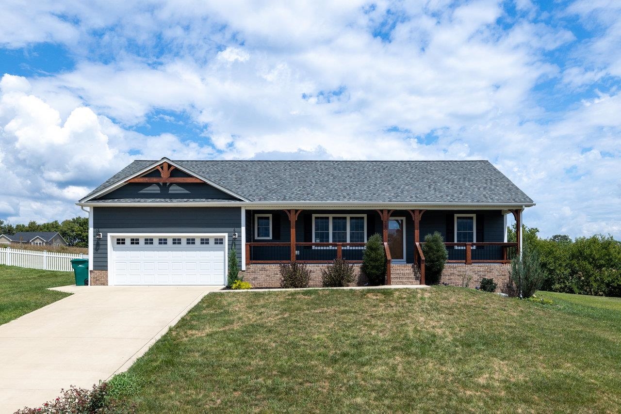 a front view of house with yard and trees in the background