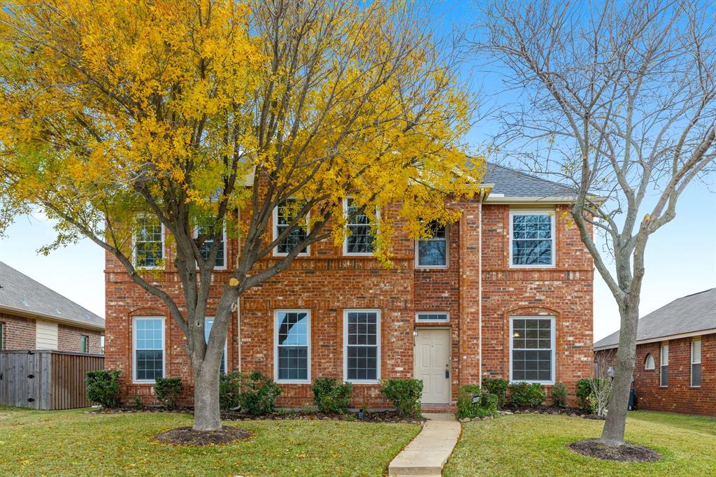 front view of a brick house with a yard