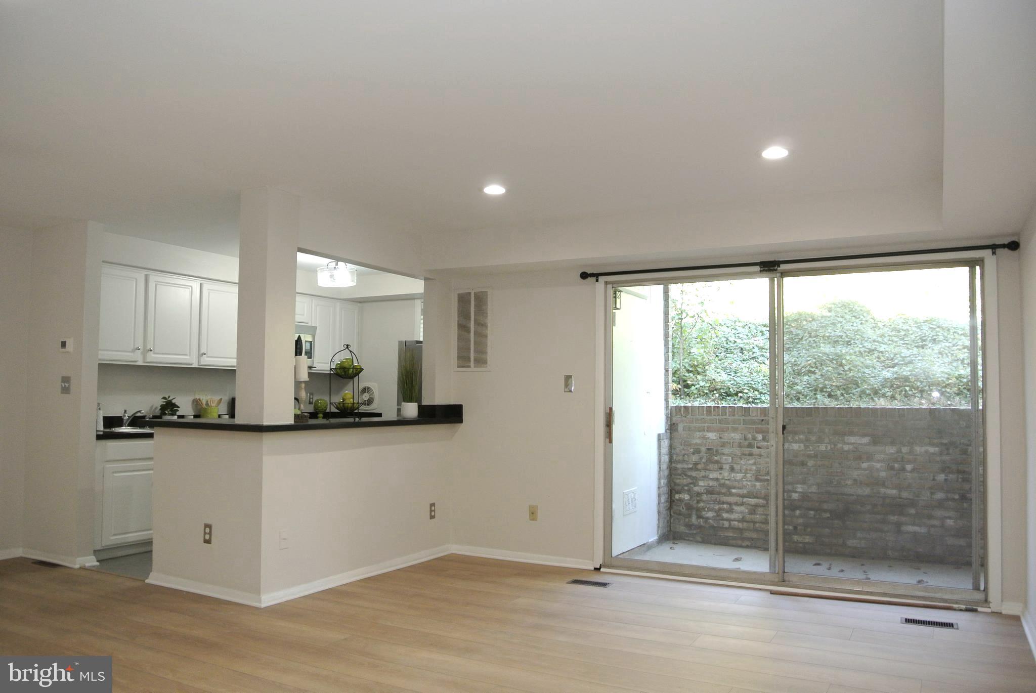 a view of a kitchen with wooden floor and a window