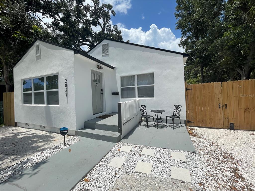 a backyard of a house with table and chairs