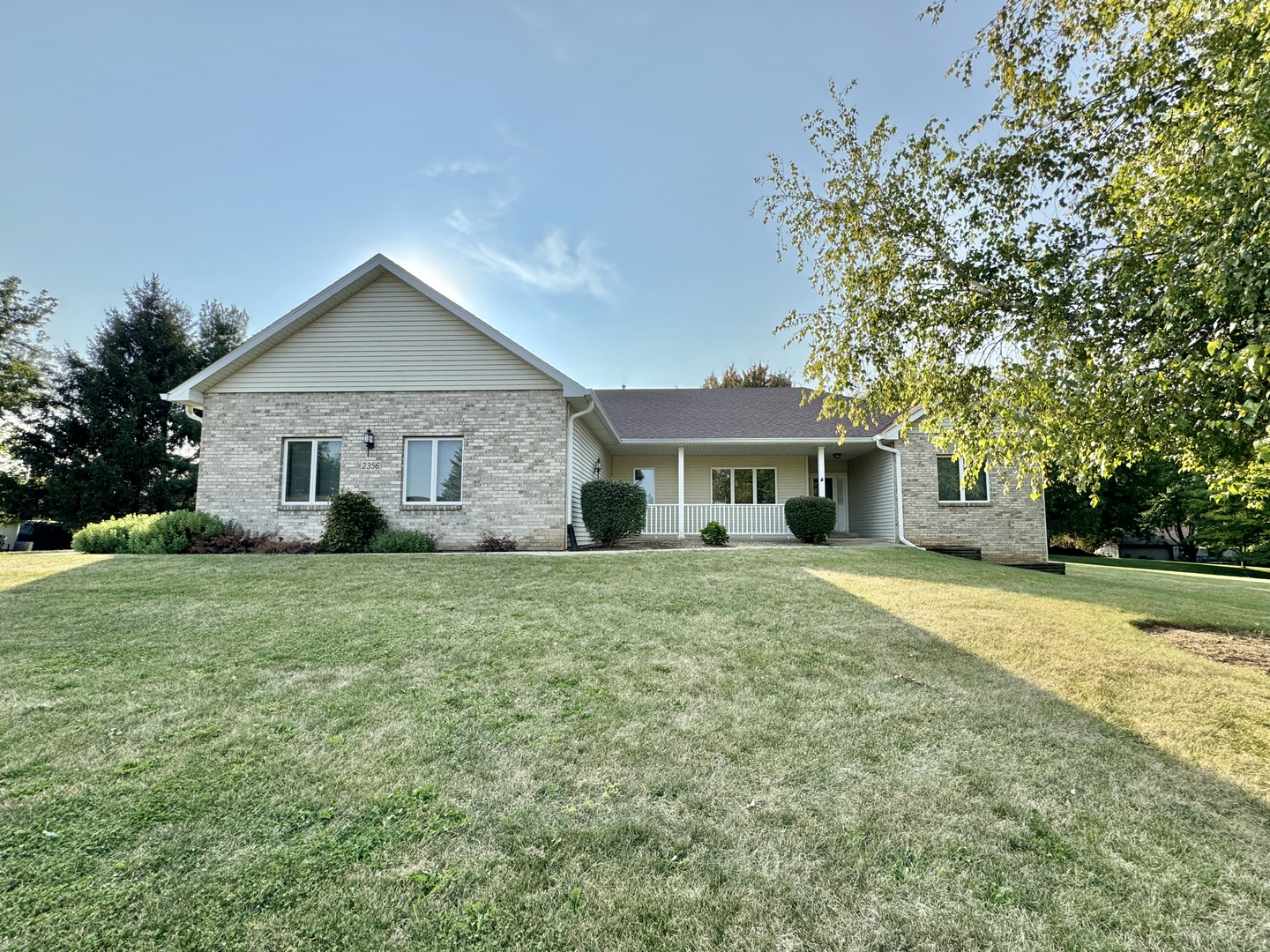 a front view of a house with a garden and trees