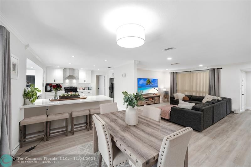 a living room with furniture kitchen view and a chandelier