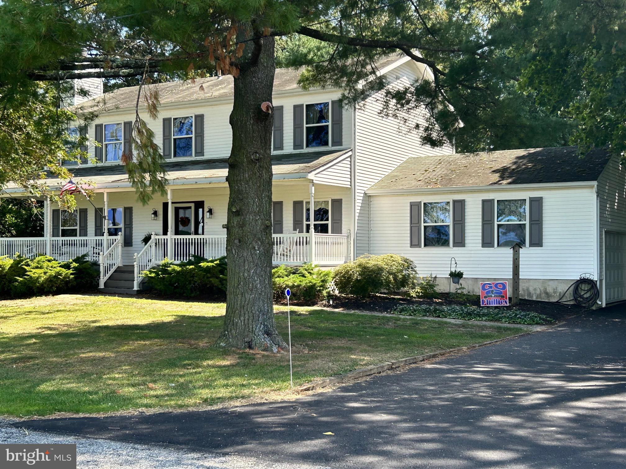 a view of a white house with a big yard and potted plants