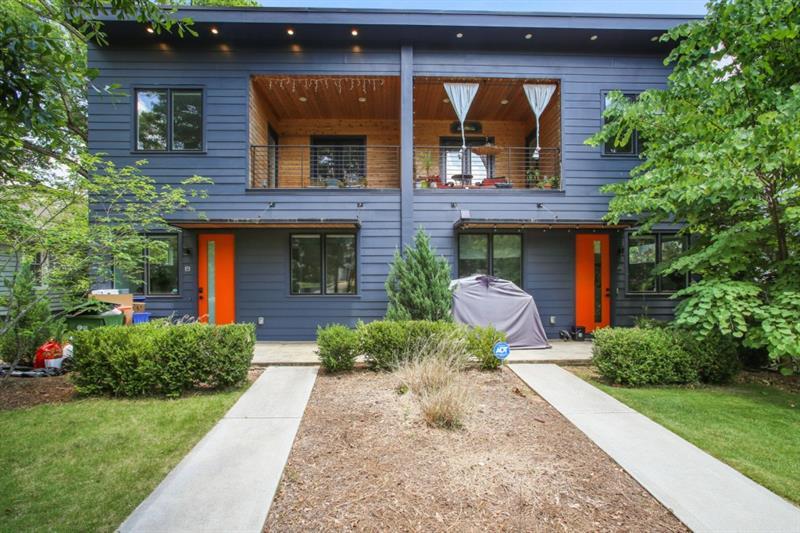 front view of a house with a yard and potted plants