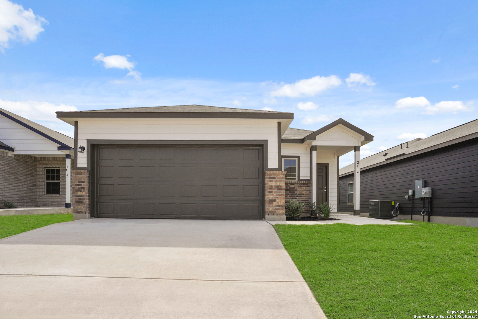 a front view of a house with a yard and garage