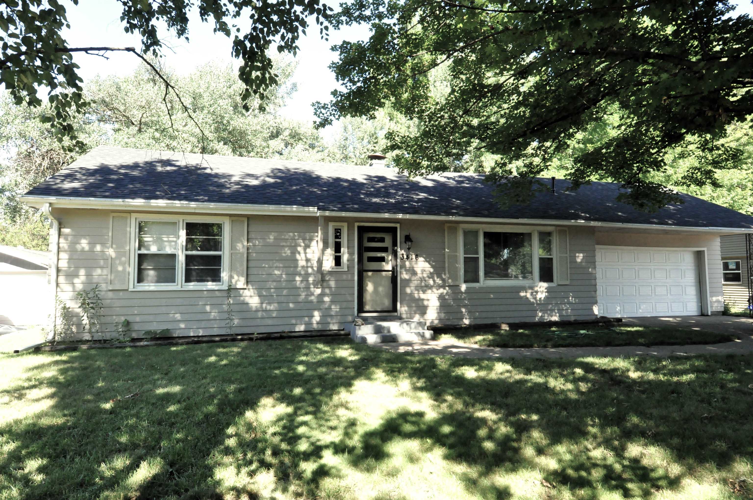 a front view of a house with a garden and yard