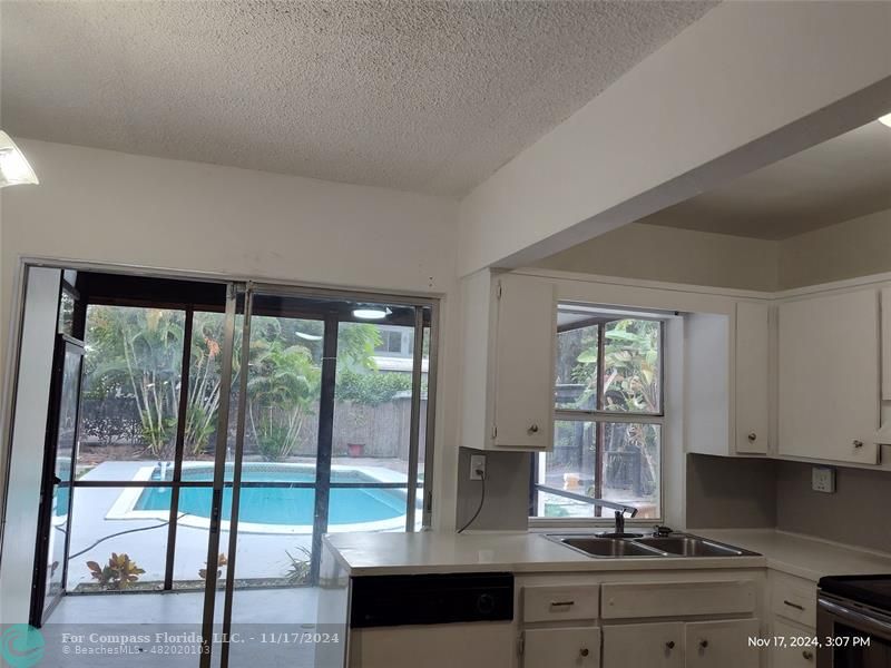 a view of kitchen with granite countertop window