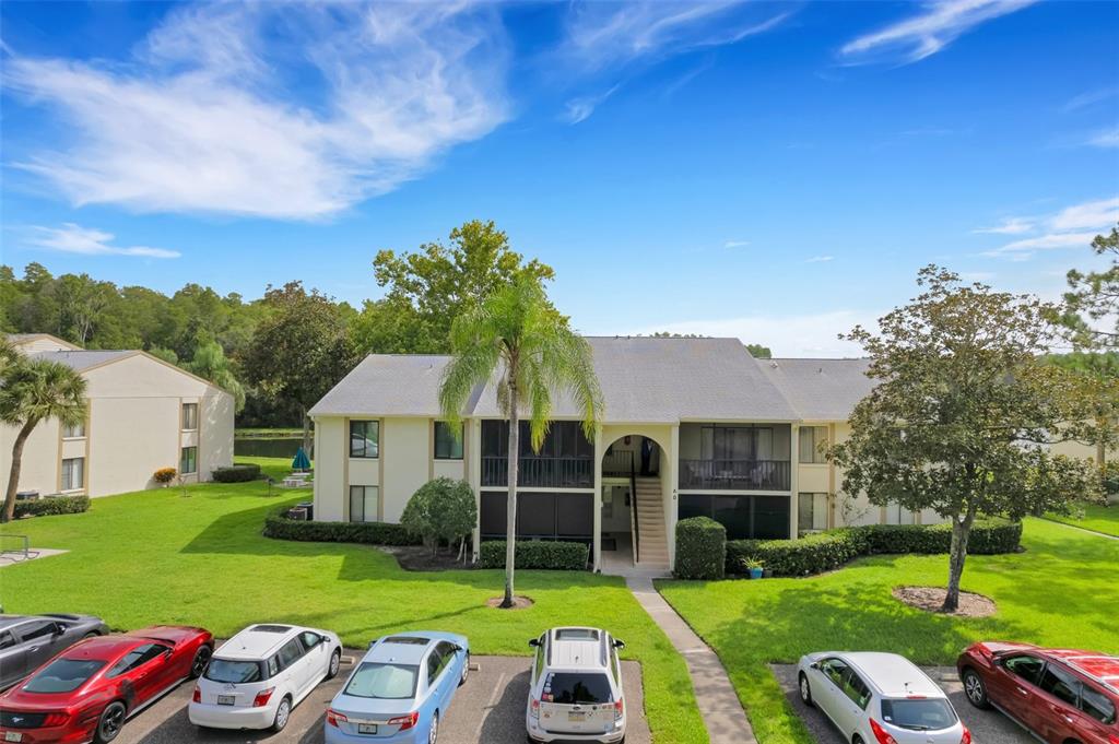 a view of a house with a big yard plants and large trees