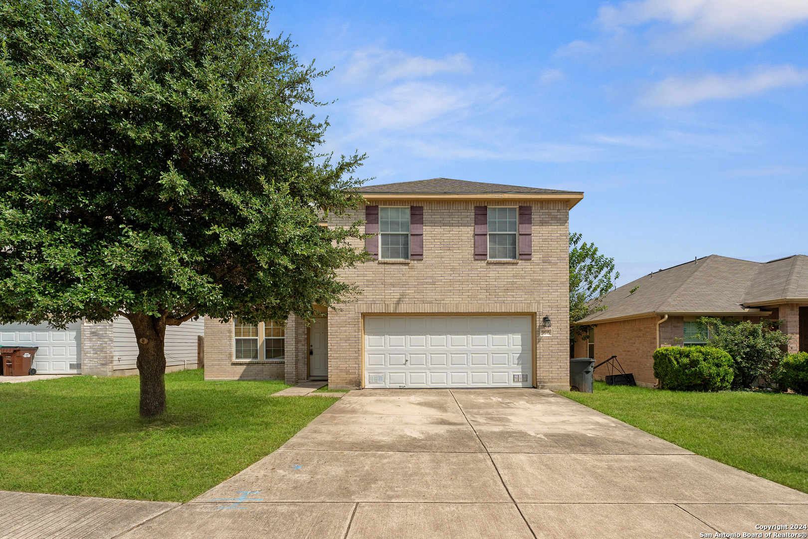 a front view of a house with a yard and a garage