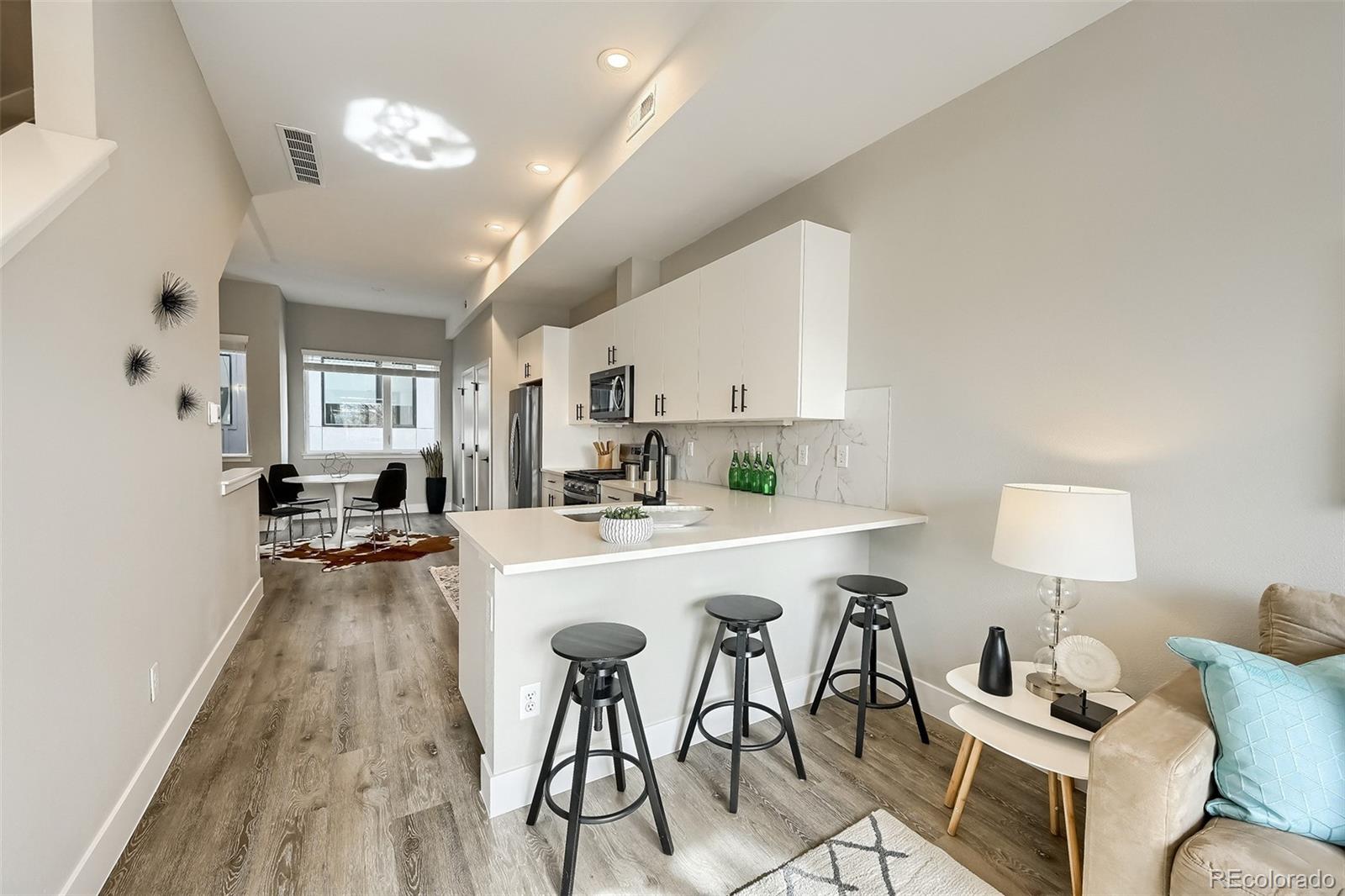 a kitchen with sink a refrigerator and chairs