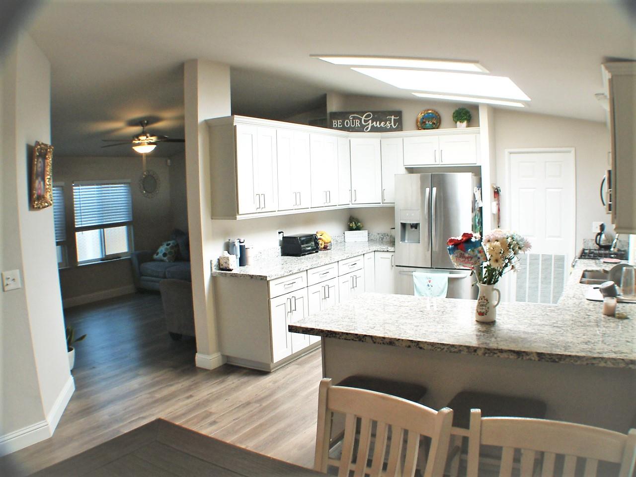 a kitchen with granite countertop a sink cabinets and wooden floor