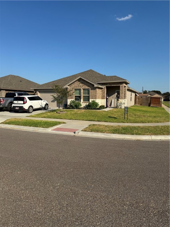 a front view of a house with a yard and car parked