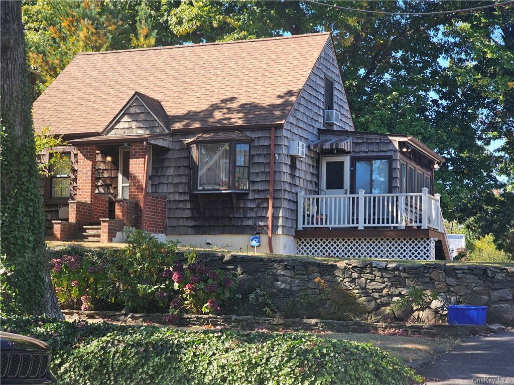 View of front facade with a wooden deck