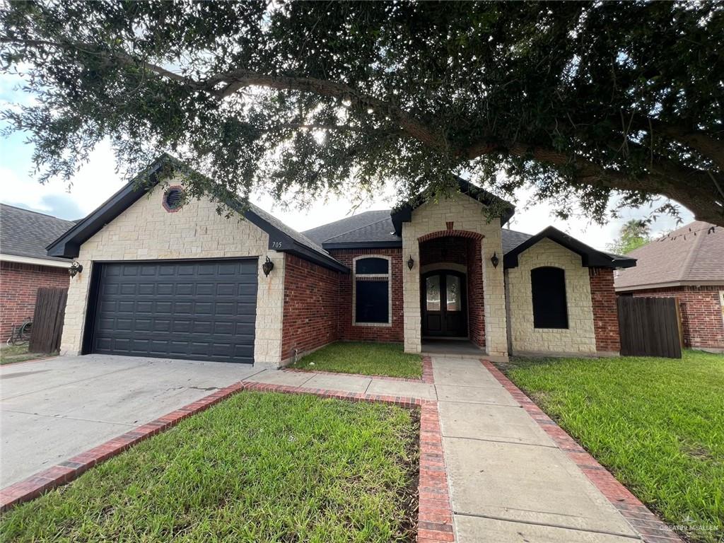 View of front of house featuring a garage and a front lawn