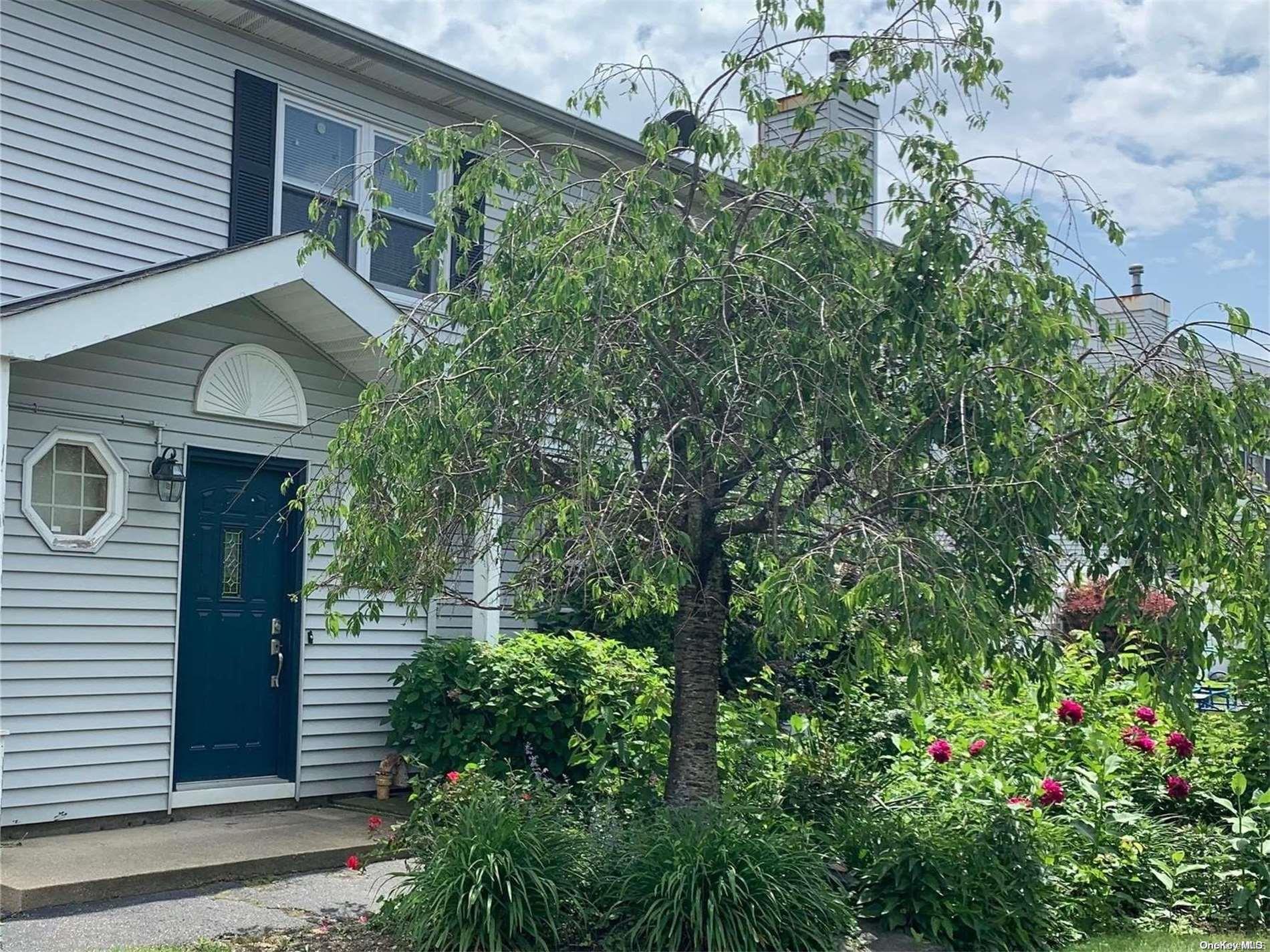 a front view of a house with plants