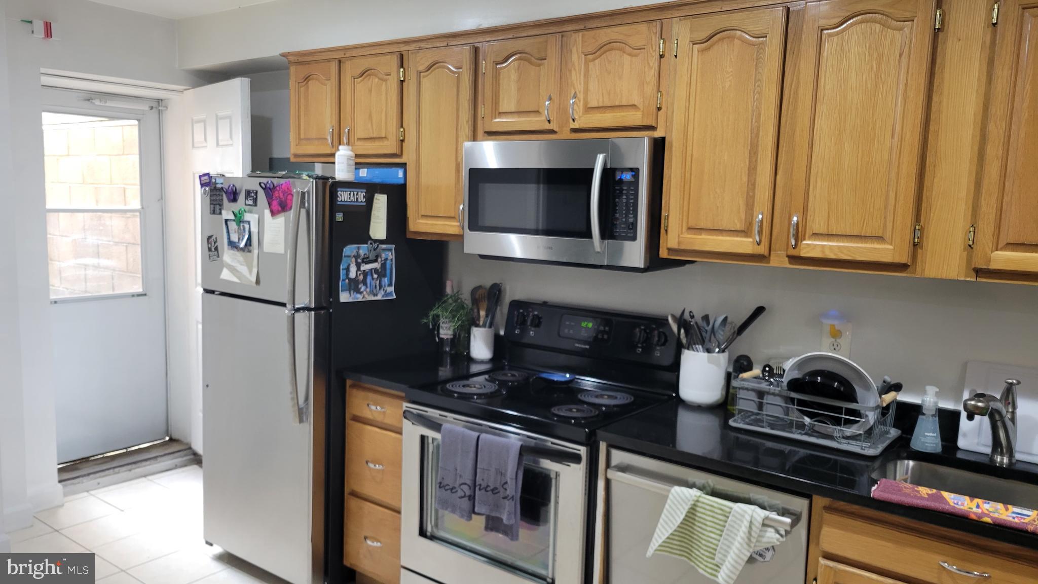 a kitchen with stainless steel appliances granite countertop a refrigerator and a stove