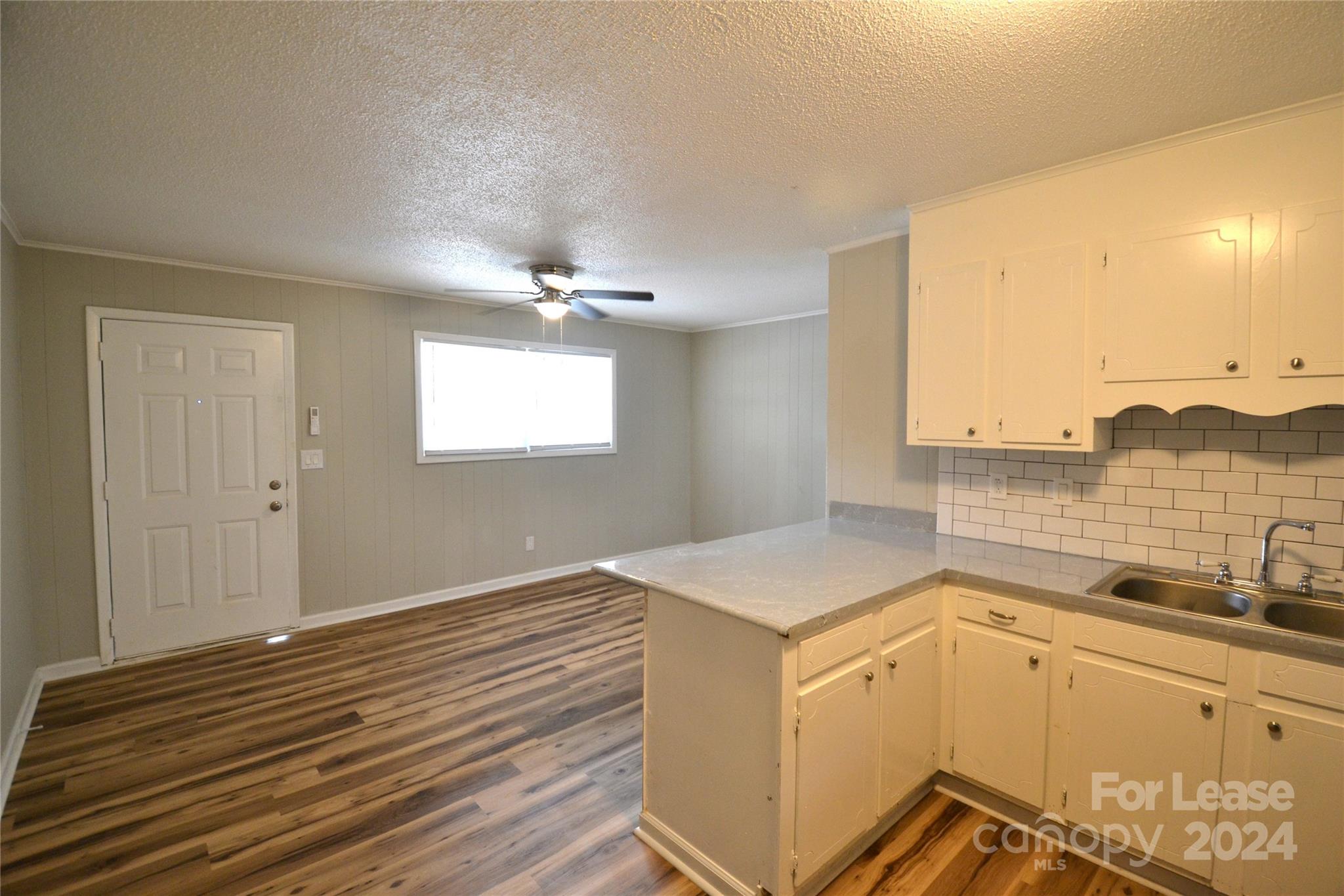 a room with a sink cabinets and wooden floor