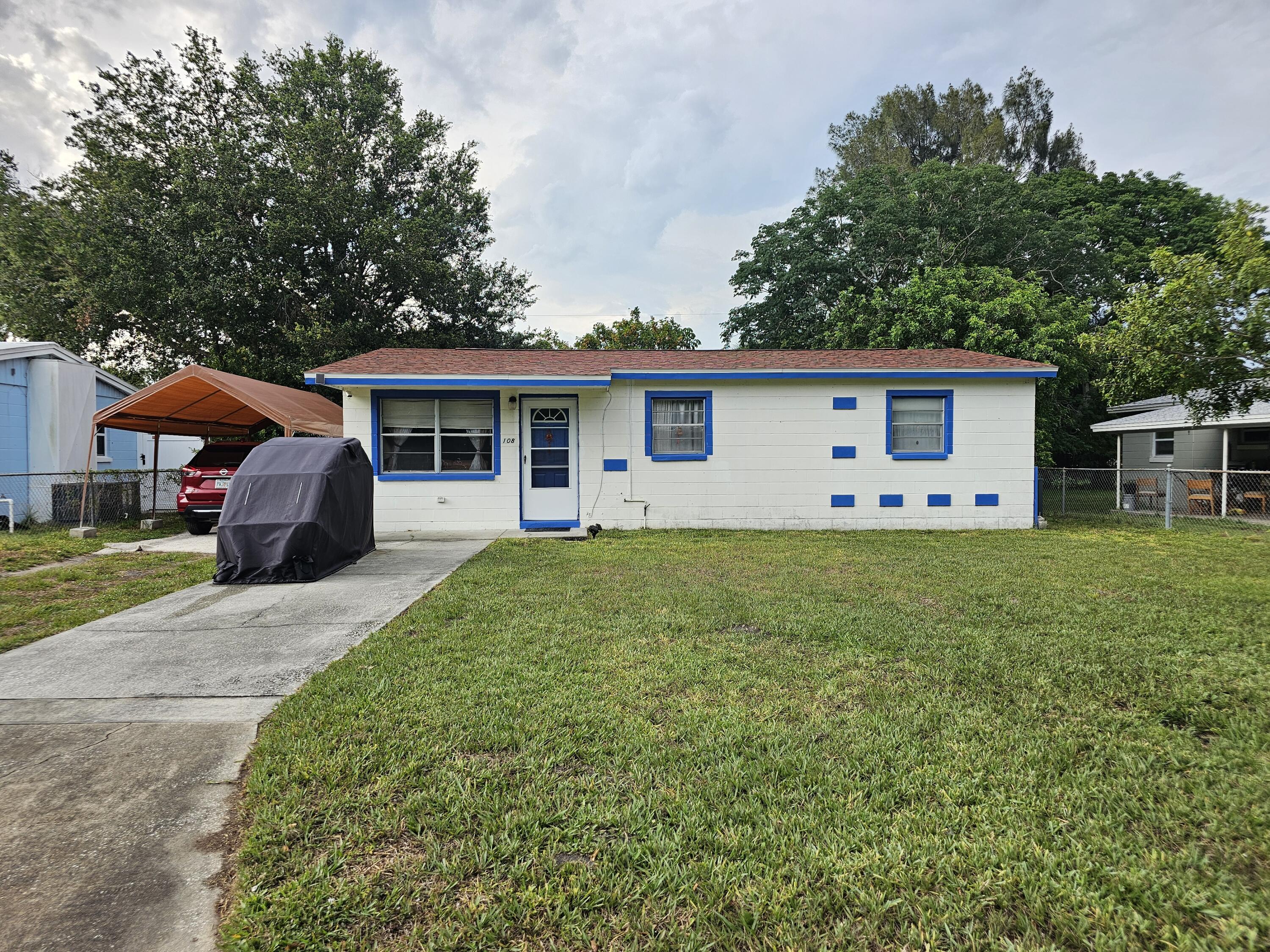 a view of a house with backyard and sitting area