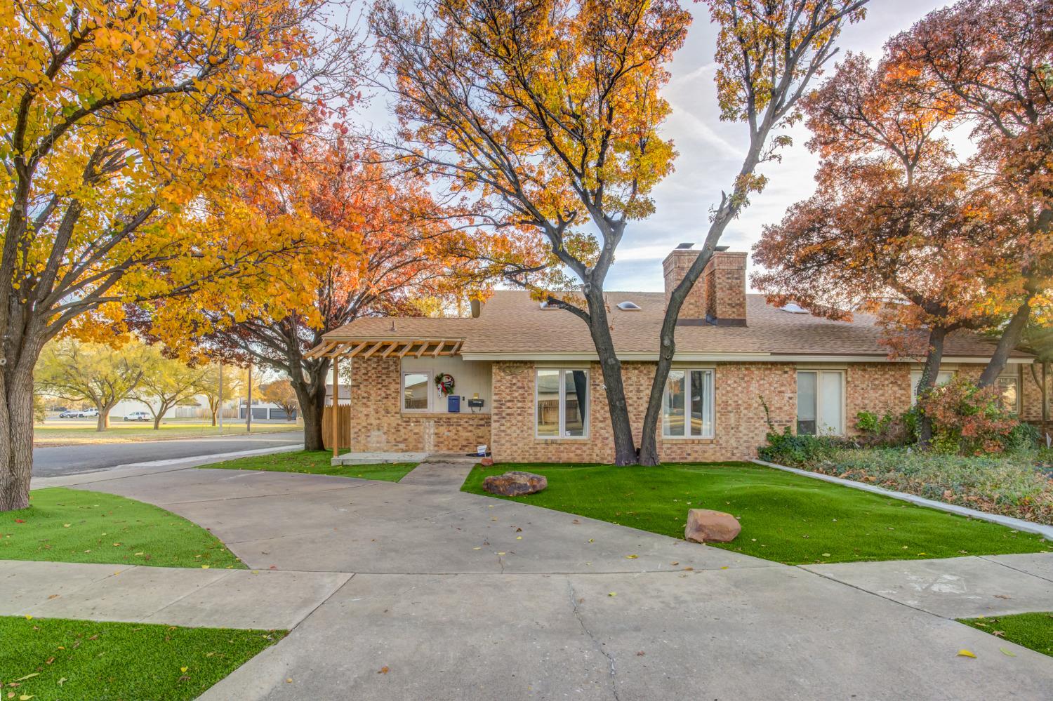 a view of a house with a big yard and large trees