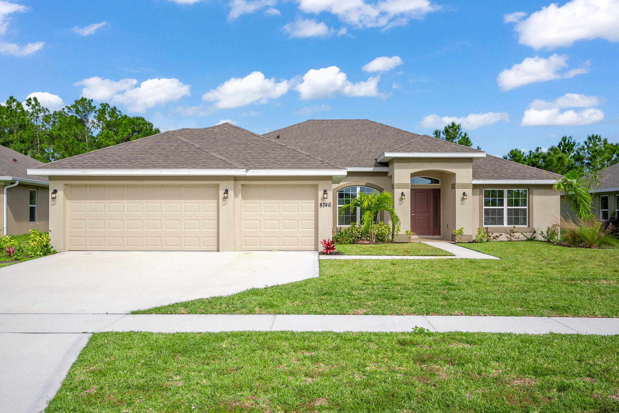 a front view of a house with a garden and yard