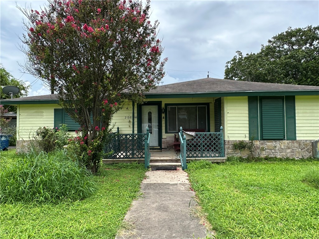 a front view of a house with a garden and yard